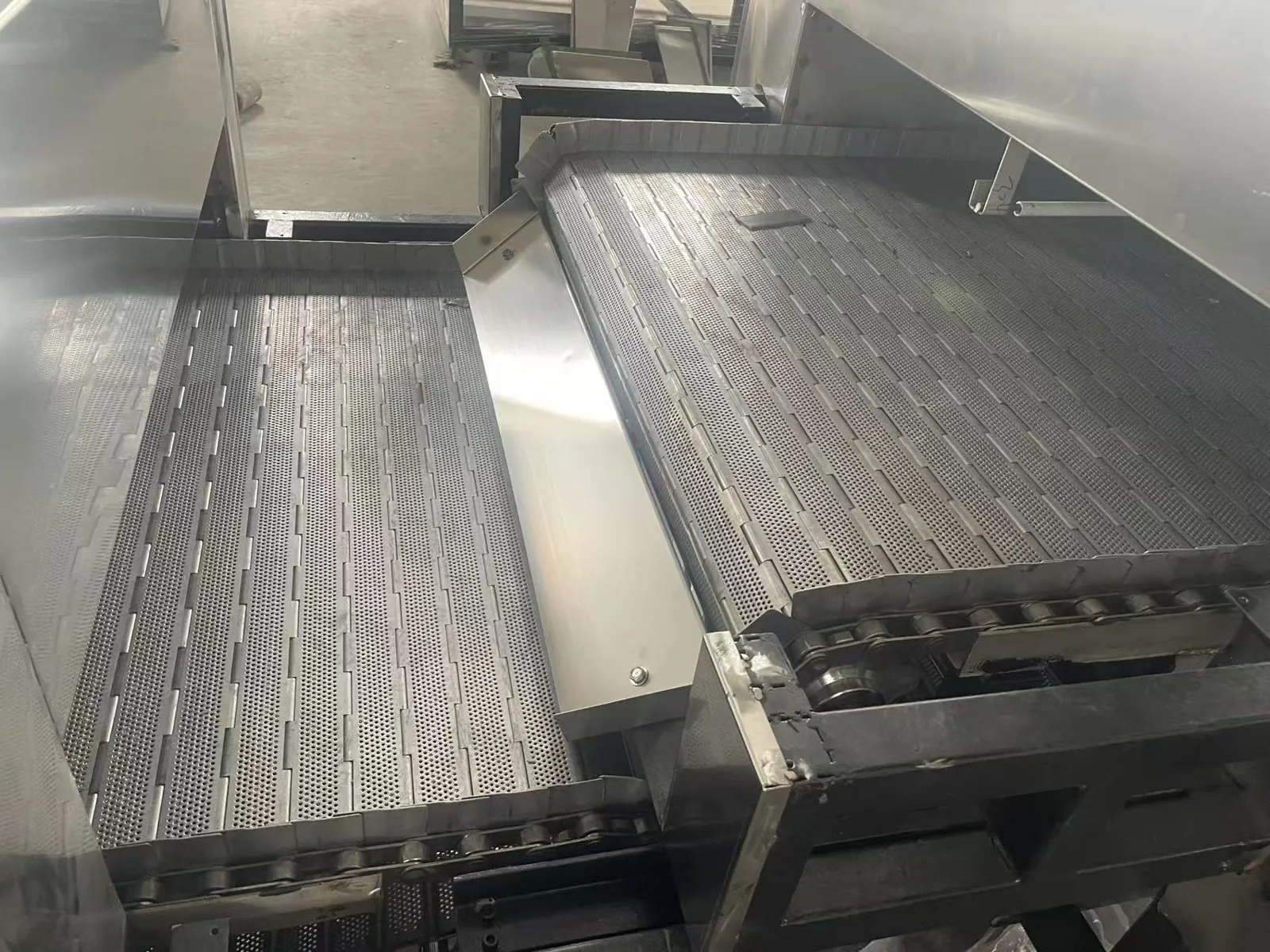 Transfer between the tunnel dryer conveyor and belt cooling section