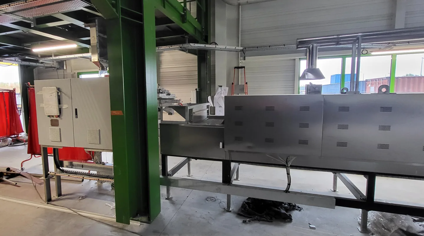 Tunnel belt dryer and electrical cabinet integrated into an existing French factory